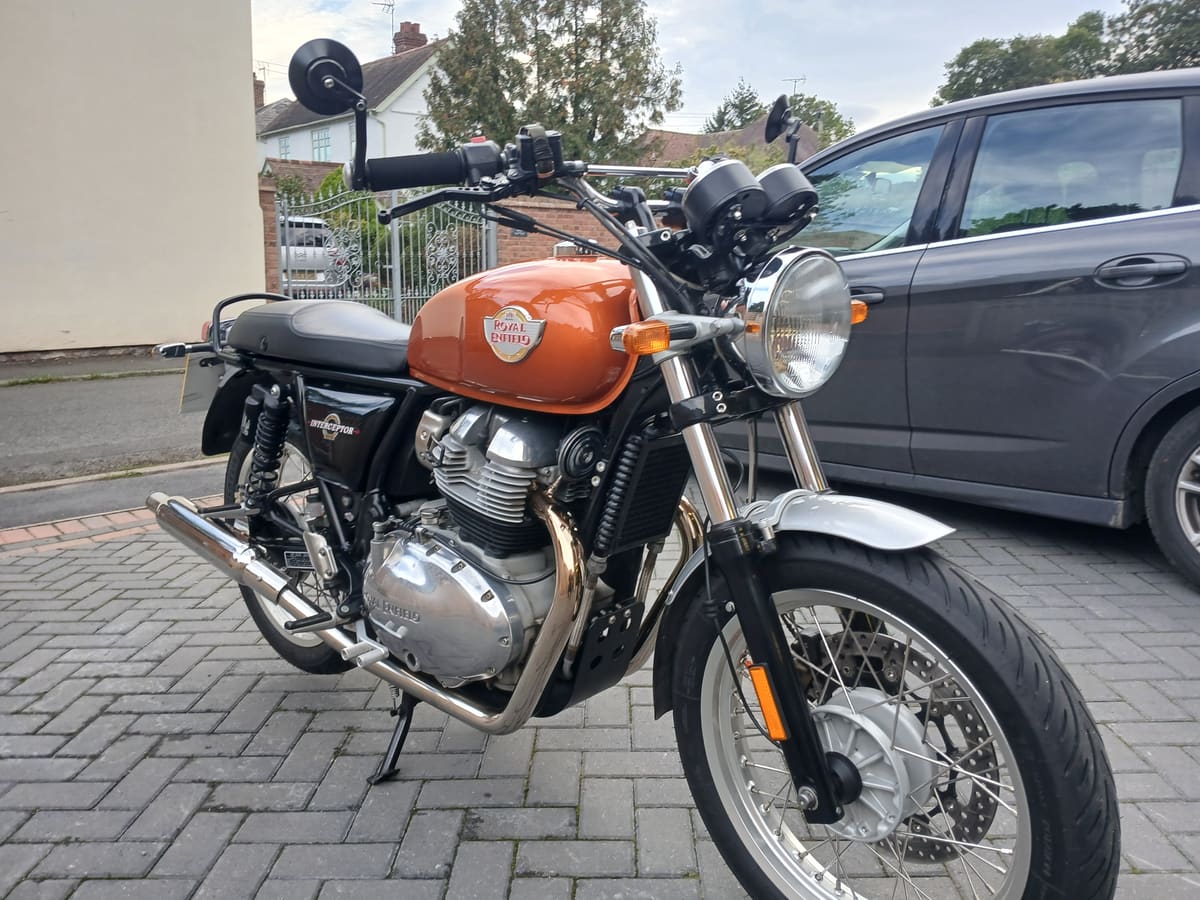 Bob, the 2020 Royal Enfield Interceptor 650, three-quarter front view showing the orange tank and bar-end mirrors